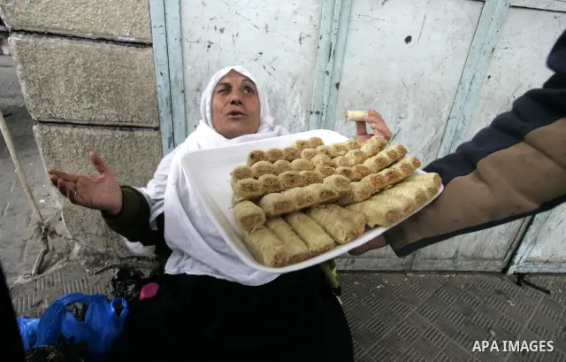 Palestinians distribute desserts celebrating the attack at the Jewish settlement of Itmar near Nablus in Rafah on March 12, 2011. A Palestinian infiltrated Itamar early Saturday and killed five people, the Israeli milita...