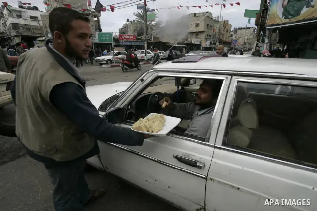 Palestinians distribute desserts celebrating the attack at the Jewish settlement of Itmar near Nablus in Rafah on March 12, 2011. A Palestinian infiltrated Itamar early Saturday and killed five people, the Israeli milita...