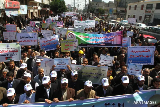 Palestinians hold signs during a protest calling for a national reconciliation between the tow parties Fatah and Hamas in Gaza City on March 12, 2011. Photo by Ashraf Amra