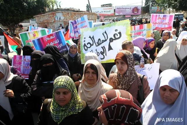 Palestinians hold signs during a protest calling for a national reconciliation between the tow parties Fatah and Hamas in Gaza City on March 12, 2011. Photo by Ashraf Amra