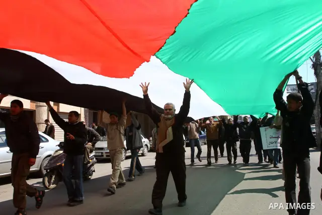 Palestinians a giant flag during a protest calling for a national reconciliation between the tow parties Fatah and Hamas in Gaza City on March 12, 2011. Photo by Ashraf Amra
