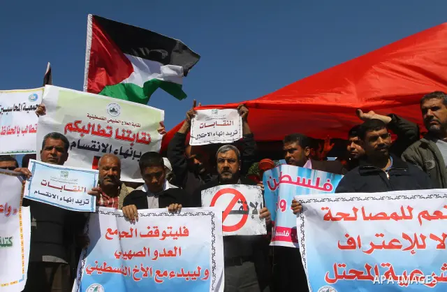 Palestinians hold signs during a protest calling for a national reconciliation between the tow parties Fatah and Hamas in Gaza City on March 12, 2011. Photo by Ashraf Amra