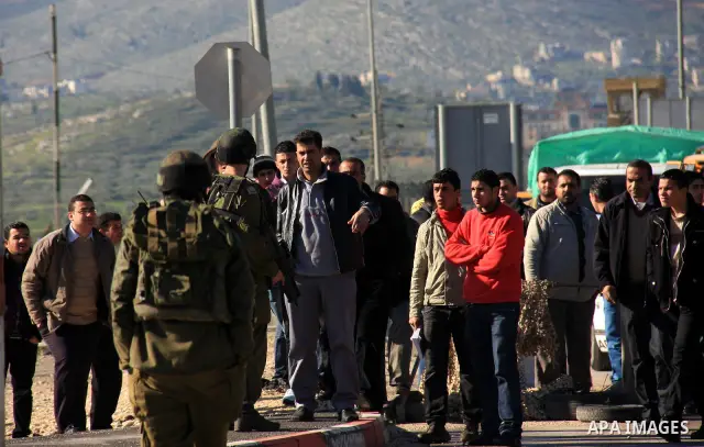 Israeli soldiers check identity cards of Palestinians at a military checkpoint of Hawara near the West Bank city of Nablus on March 12, 2011. The Israeli army announced the Palestinian city as closed military zone follow...