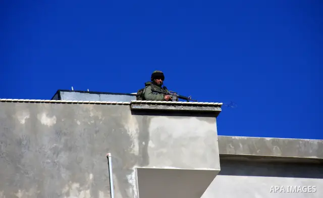 Israelis soldiers watch on the roof of houses in the village of Awarta near the West Bank town of Nablus, March 12, 2011. A Palestinian infiltrated a Jewish West Bank settlement early killed five people, the Israeli mili...