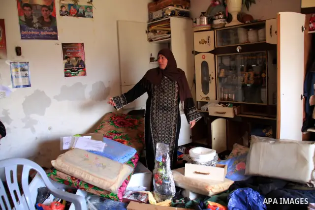 A Palestinian woman inspects damaged room after Israeli army stormed her house, arrested four of her sons in the West Bank village of Awarta near Nablus on March 12, 2011. The Israeli army arrested at least 18 Palestinia...
