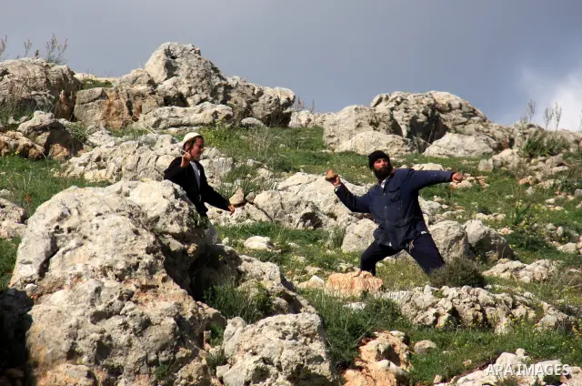 Israeli settlers from the Bracha settlement throw stones at Palestinian youth in the West Bank village of Burin on March 12, 2011 during clashes after an overnight attack in which five members of an Israeli family were k...