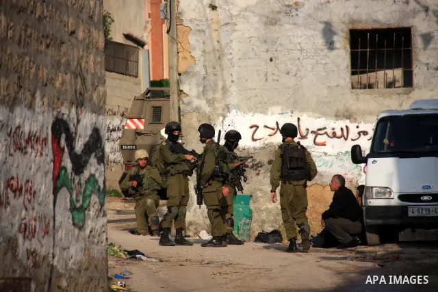 Israeli soldiers take position at Awarta Village south of the West Bank city of Nablus during a search operation on 12 March ,2011. The Israeli army announced the Palestinian city as closed military zone following the ki...