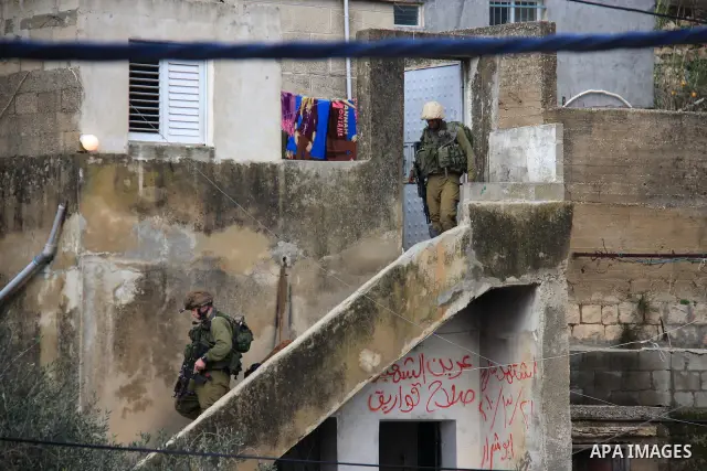 Israeli soldiers take position at Awarta Village south of the West Bank city of Nablus during a search operation on 12 March ,2011. The Israeli army announced the Palestinian city as closed military zone following the ki...