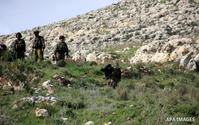 Israeli soldiers take position durin clashes between settlers from the Bracha settlement and Palestinian youths in the West Bank village of Burin on March 12, 2011 during clashes after an overnight attack in which five m...