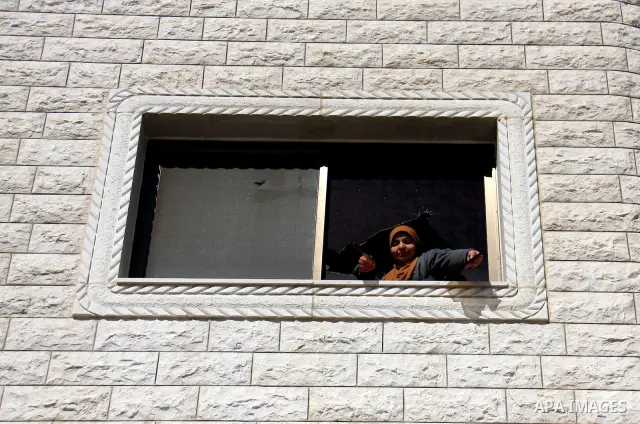 Palestinian woman hand by the broken window of her family house after Israeli Jewish settlers attack near the village of Hawara in the west bank, Sunday , March 13, 2011. Photo by Wagdi Eshtayah