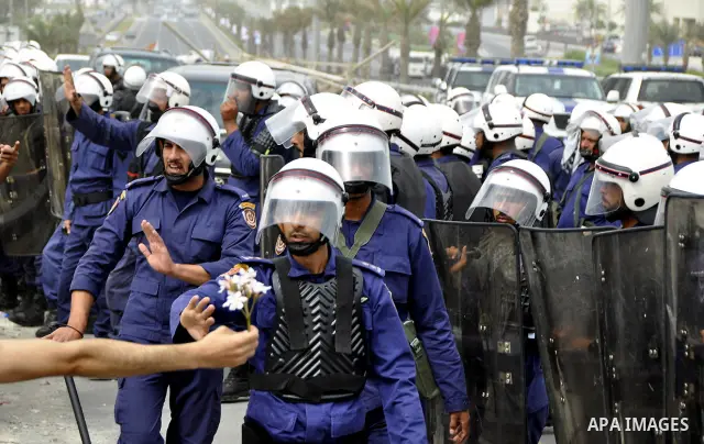 Bahraini anti-government protesters demonstrate in front of riot police on an overpass near Pearl roundabout Sunday, March 13, 2011, in Manama, Bahrain. Photo by Ammar A.rasool