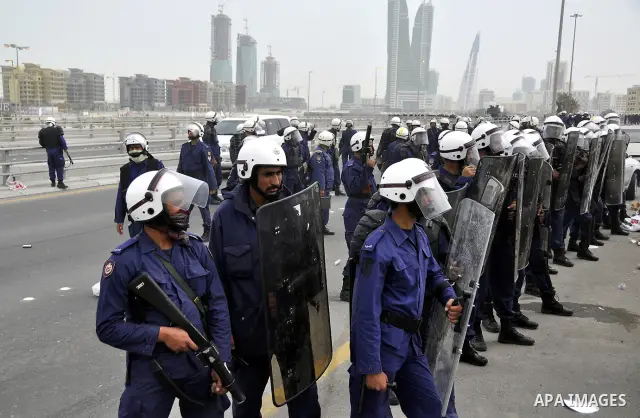 Bahraini anti-government protesters demonstrate in front of riot police on an overpass near Pearl roundabout Sunday, March 13, 2011, in Manama, Bahrain. Photo by Ammar A.rasool