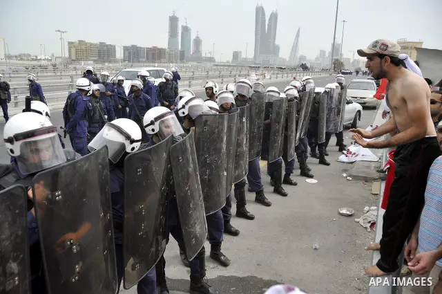 Bahraini anti-government protesters demonstrate in front of riot police on an overpass near Pearl roundabout Sunday, March 13, 2011, in Manama, Bahrain. Photo by Ammar A.rasool