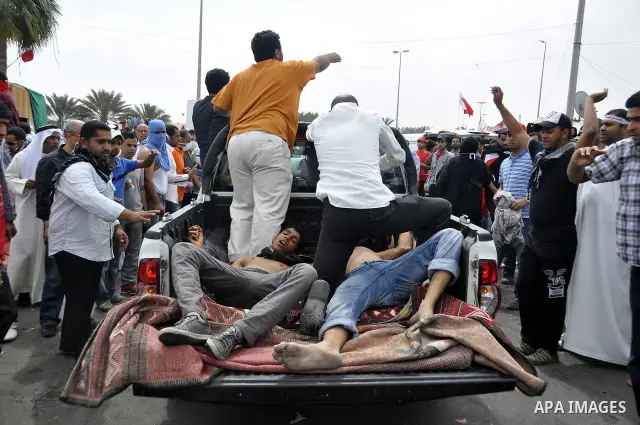 Anti-government protesters carry away fellow demonstrators who was overcome by tear gas fired by riot police Sunday, March 13, 2011, along a main highway in Manama, Bahrain. Photo by Ammar A.rasool