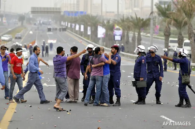 Bahraini anti-government protesters demonstrate in front of riot police on an overpass near Pearl roundabout Sunday, March 13, 2011, in Manama, Bahrain. Photo by Ammar A.rasool