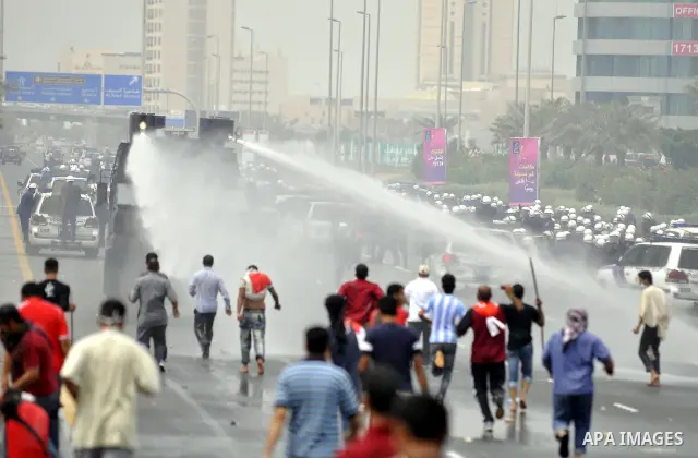 Anti-government protesters react to tear gas fired by riot police Sunday, March 13, 2011, along a main highway in Manama, Bahrain. Photo by Ammar A.rasool