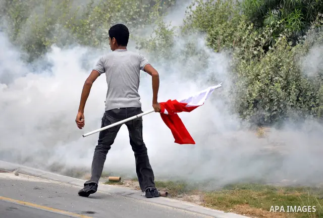 Anti-government protesters react to tear gas fired by riot police Sunday, March 13, 2011, along a main highway in Manama, Bahrain. Photo by Ammar A.rasool