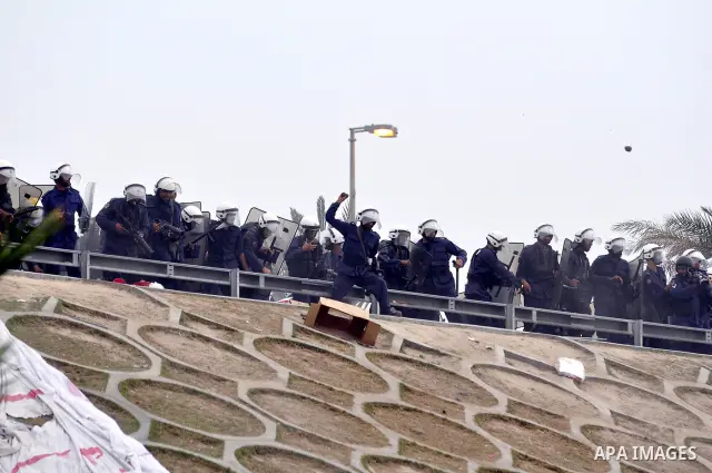 Bahraini anti-government protesters demonstrate in front of riot police on an overpass near Pearl roundabout Sunday, March 13, 2011, in Manama, Bahrain. Photo by Ammar A.rasool