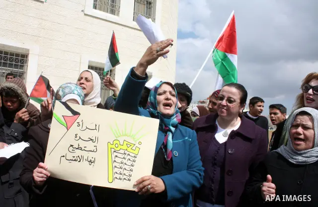 Palestinian women protestors hold national flags and banners calling for the national reconciliation in front of the Governorate of Hebron in the West Bank city of Hebron,on March 13, 2011. Photo by Najeh Hashlamoun