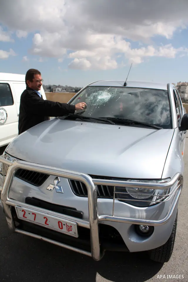 Palestinian man inspects his broken glass car after Israeli settlers throw stones towards Palestinian cars Saturday night in the West Bank city of Hebron on March 13, 2011. Photo by Najeh Hashlamoun..
