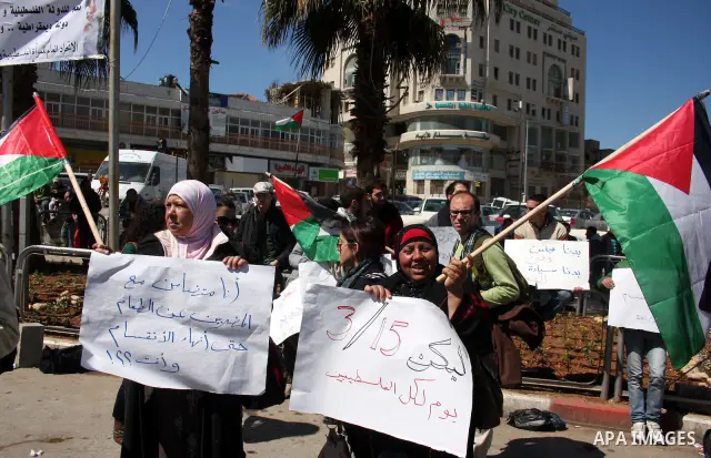 Palestinians participate in a march calling for a reconciliation between the rival Palestinian leading factions Hamas in Gaza and Fatah in the West Bank, in Ramallah, Monday, March 14, 2011. Photo by Issam Rimawi