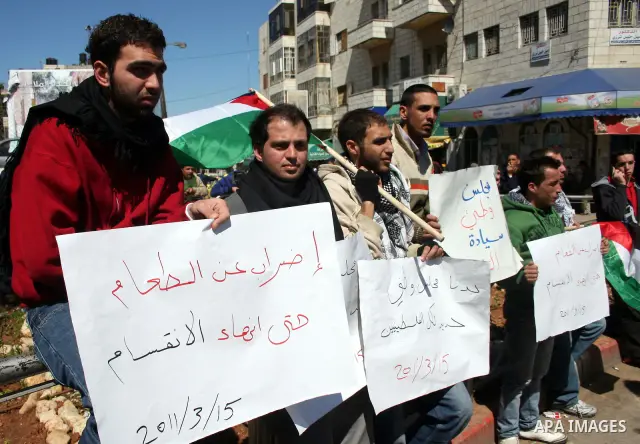 Palestinians participate in a march calling for a reconciliation between the rival Palestinian leading factions Hamas in Gaza and Fatah in the West Bank, in Ramallah, Monday, March 14, 2011. Photo by Issam Rimawi