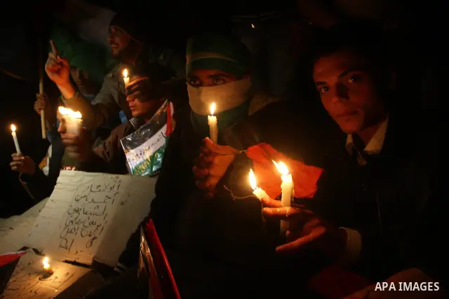 Palestinian demonstrators hold candles and placards as they prepare to spend the night on the street during a rally in Gaza City, calling for an end to Palestinian divisions March 14, 2011. Some 500 Palestinians, answeri...