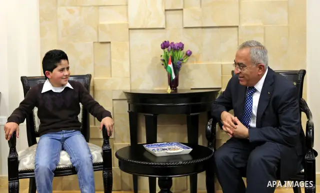 Palestinian Prime Minister Salam Fayyad meets the child Issam Bashiti in the West Bank city of Ramallah March 15, 2011. Photo by Mustafa Abu Dayeh
