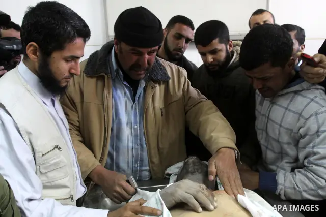 Palestinians stand next to the body of a Hamas militant killed in an Israeli air strike on a Hamas training camp, after they were brought to the morgue of Shifa hospital in Gaza City, Wednesday, March 16, 2011. Israeli f...