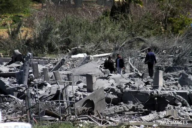 A Palestinian Hamas security officer walks through the rubble after an Israeli air strike on a Hamas training camp on the outskirts of Gaza City, Wednesday, March 16, 2011. Israeli fighter jets pummeled a Hamas facility...