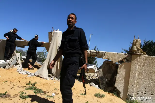 A Palestinian Hamas security officer walks through the rubble after an Israeli air strike on a Hamas training camp on the outskirts of Gaza City, Wednesday, March 16, 2011. Israeli fighter jets pummeled a Hamas facility...