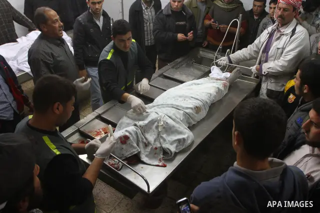 Palestinians stand next to the body of a Hamas militant killed in an Israeli air strike on a Hamas training camp, after is was brought to the morgue of Shifa hospital in Gaza City, Wednesday, March 16, 2011. Israeli figh...