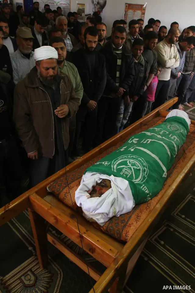 Palestinians pray near the body of Hamas militant Adnan Ishtawe during his funeral in Gaza City March 16, 2011. Israeli warplanes fired two missiles at a security compound in the Hamas-ruled Gaza Strip on Wednesday, kill...