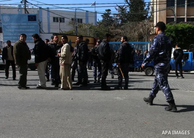 An armed Palestinian Hamas security members tries to disperse Palestinian demonstrators blocking the street opposite the headquarters of the United Nations Relief and Works Agency for Palestine Refugees in the Near East...