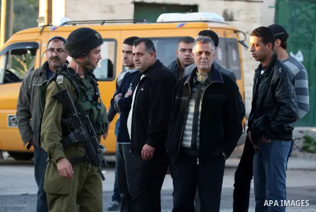 Israeli soldiers stand guard near the Israeli settlement of Qadumim between Qalqilya and Nablus in the West Bank after settlers torched the cars of two Palestinians working inside the settlement on March 17, 201. Photo b...