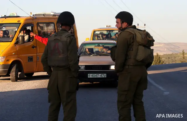 Israeli soldiers stand guard near the Israeli settlement of Qadumim between Qalqilya and Nablus in the West Bank after settlers torched the cars of two Palestinians working inside the settlement on March 17, 201. Photo b...