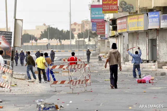 Anti-government protesters run from riot police, Thursday, March 17, 2011, as a tear gas canister explodes nearby in the Shiite Muslim village of Jidhafs, Bahrain, on the outskirts of the capital of Manama. Security forc...