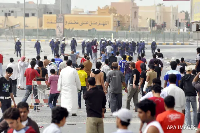 Anti-government protesters run from riot police, Thursday, March 17, 2011, as a tear gas canister explodes nearby in the Shiite Muslim village of Jidhafs, Bahrain, on the outskirts of the capital of Manama. Security forc...