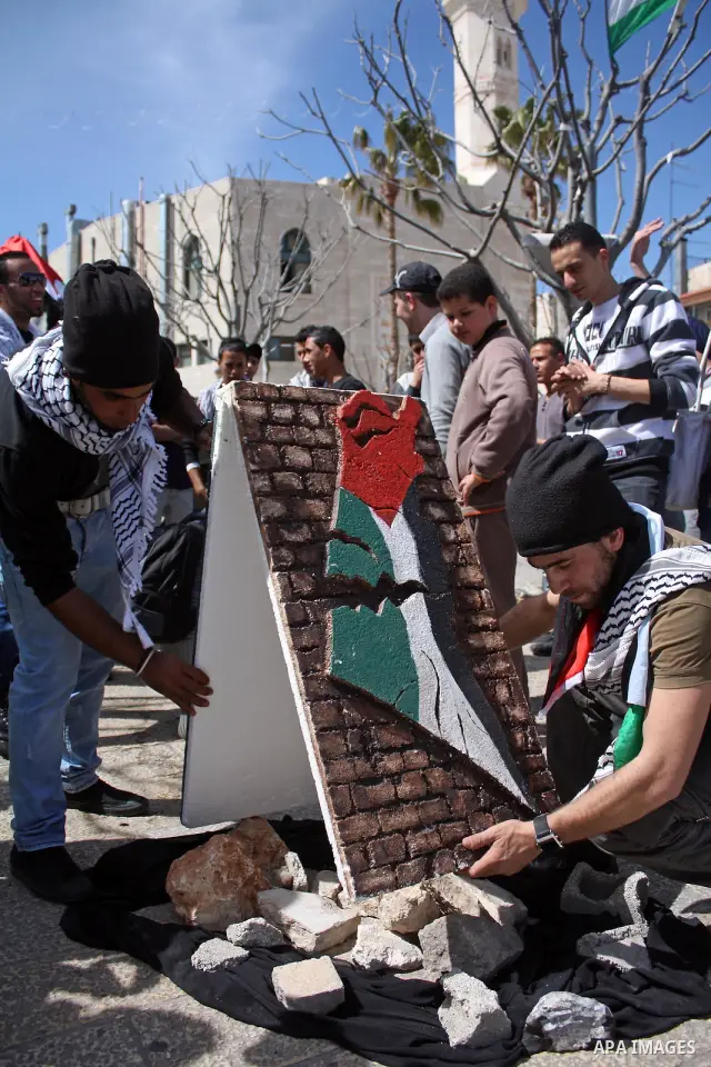 Palestinians chant slogans as they set up a tent in Manager Square in front of the Church of the Nativity in the West Bank city of Bethlehem on March 18, 2011 during a protest calling for Palestinian political unity betw...