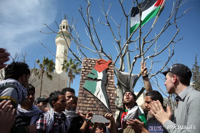 Palestinians chant slogans as they set up a tent in Manager Square in front of the Church of the Nativity in the West Bank city of Bethlehem on March 18, 2011 during a protest calling for Palestinian political unity betw...