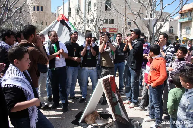 Palestinians chant slogans as they set up a tent in Manager Square in front of the Church of the Nativity in the West Bank city of Bethlehem on March 18, 2011 during a protest calling for Palestinian political unity betw...
