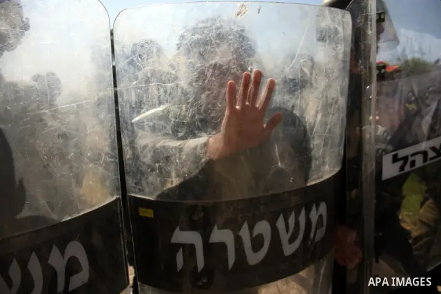 Israeli soldiers stand guard during clashes with Palestinian youths following a weekly demonstration against Israel's separation barrier in the West Bank village of Bilin on March 18, 2011. Photo by Issam Rimawi