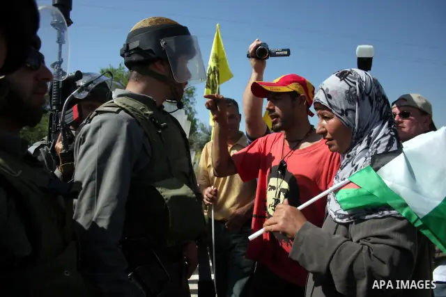 Israeli soldiers argue with Palestinians during clashes following a weekly demonstration against Israel's separation barrier in the West Bank village of Bilin on March 18, 2011. Photo by Issam Rimawi