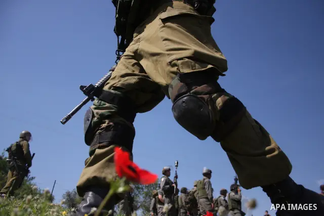 Israeli soldiers stand guard during clashes with Palestinian youths following a weekly demonstration against Israel's separation barrier in the West Bank village of Bilin on March 18, 2011. Photo by Issam Rimawi