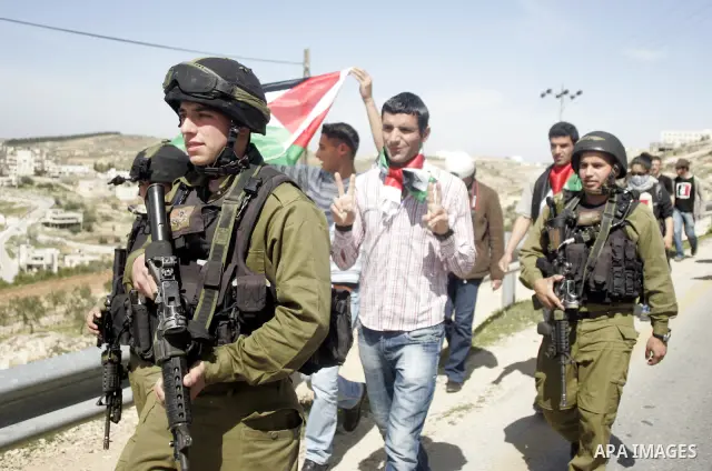 Protesters argue with an Israeli soldier during a demonstration against Israel's controversial separation barrier in the West Bank village of Maasarah, near the biblical town of Bethlehem on March 18, 2011.Israel says th...