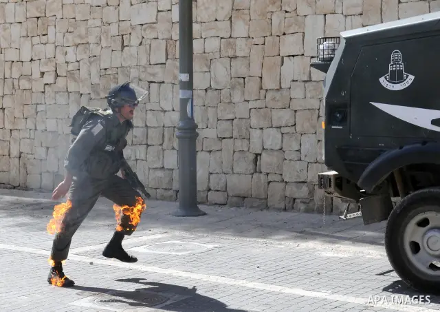 An Israeli border police tries to escape from a Molotov cocktail thrown by Palestinian youths, during clashes in the east Jerusalem neighborhood of Silwan, Friday, March 18, 2011. Photo by Sliman Khader