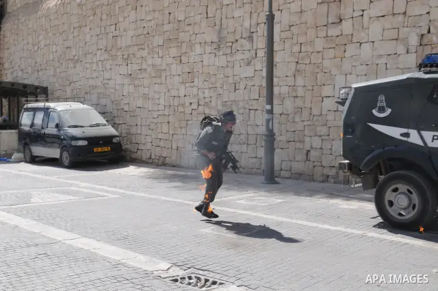 An Israeli border police tries to escape from a Molotov cocktail thrown by Palestinian youths, during clashes in the east Jerusalem neighborhood of Silwan, Friday, March 18, 2011. Photo by Sliman Khader