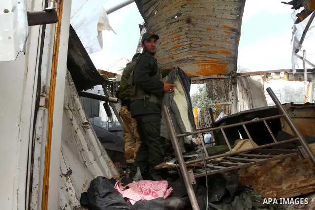 A Palestinian member of the Hamas security forces surveys the scene after Israeli strikes on the Gaza Strip . Israeli strikes on the Gaza Strip wounded five Hamas security officers and a boy on Saturday after militants l...