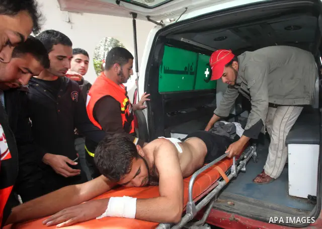 Palestinians carry a wounded member of the Hamas security forces after Israeli strikes on the Gaza Strip . Israeli strikes on the Gaza Strip wounded five Hamas security officers and a boy on Saturday after militants laun...