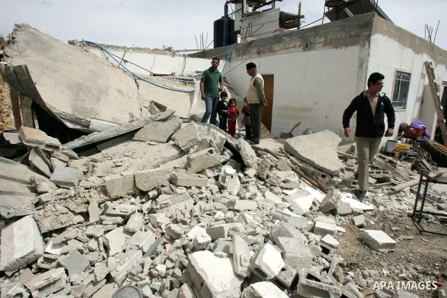Palestinians stand on the rubble of their house after it was demolished by Israeli army in the Arab Jerusalem neighborhood of Sour Baher on March 19, 2011. Photo by Mahfouz Abu Turk
